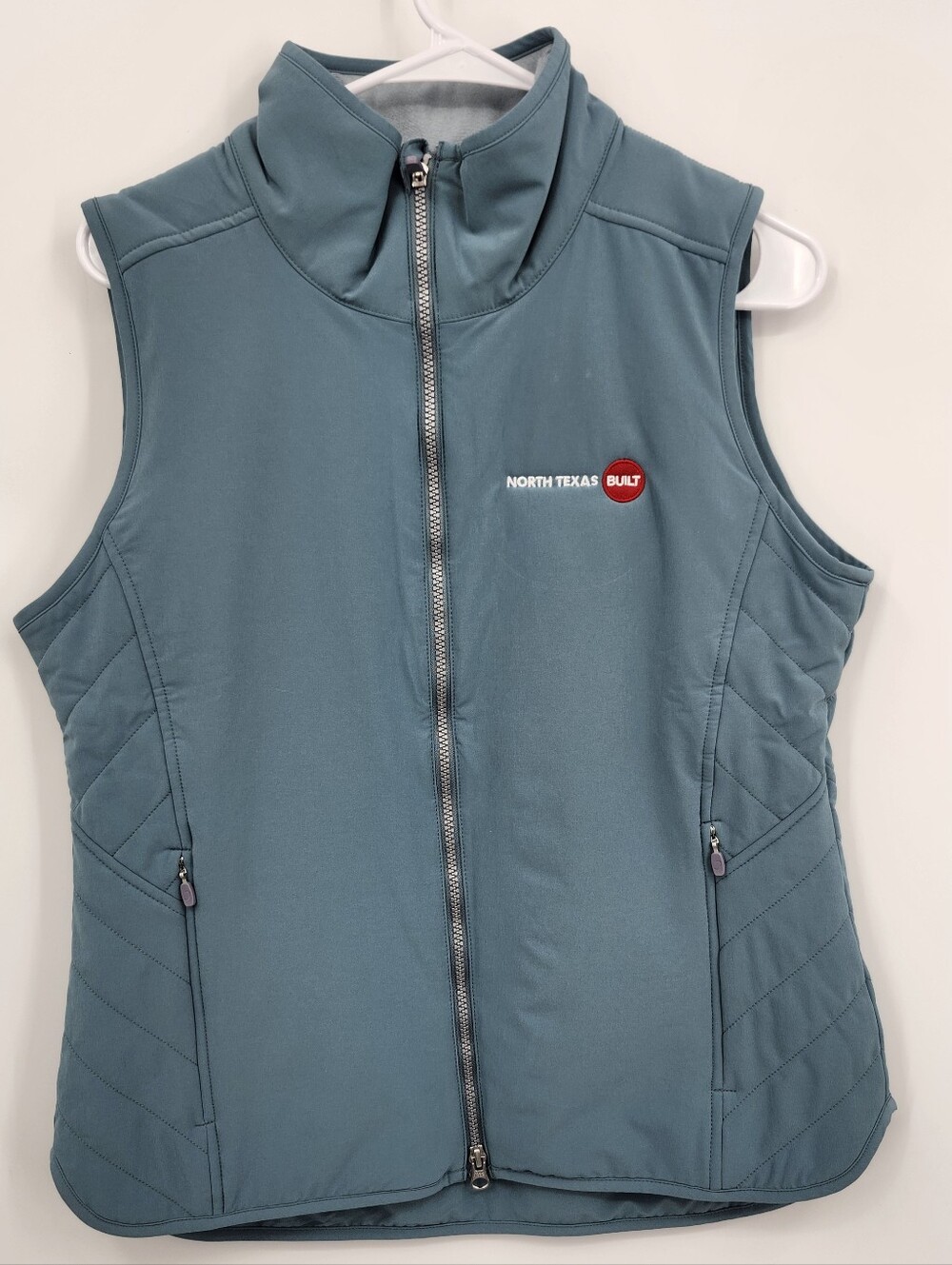 Zero restriction vest teal with company logo on it  SzM